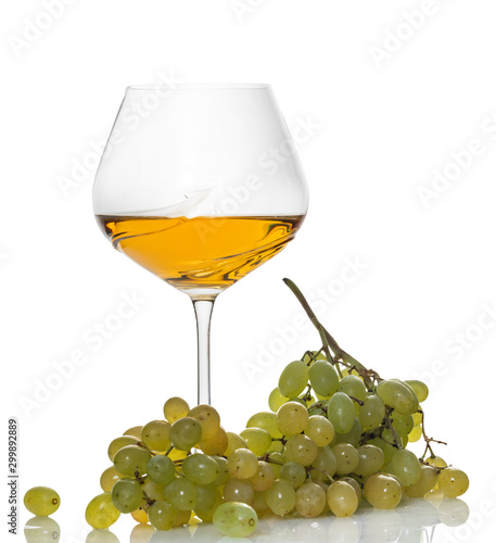 glass of white wine with a bunch of grapes