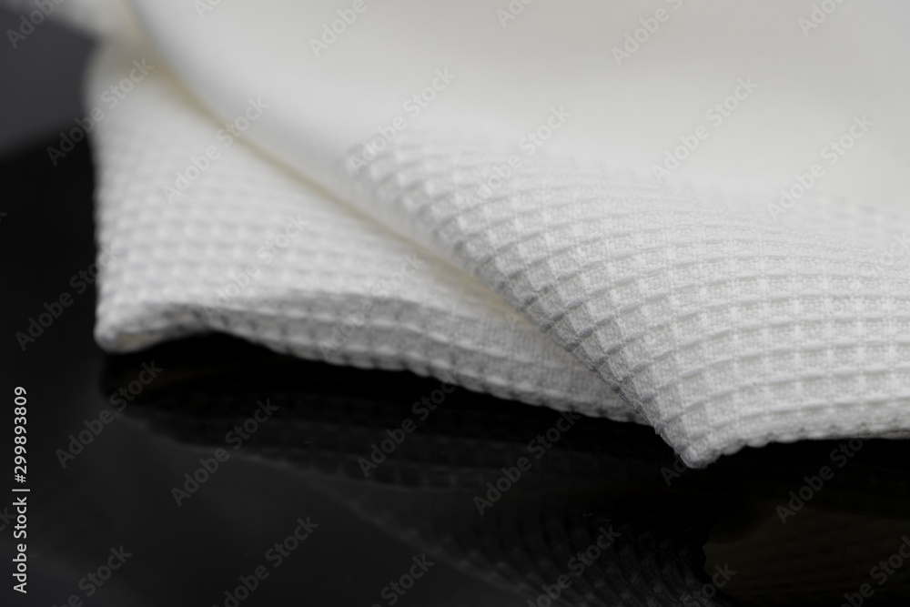 Macro shot texture of folded white towel kitchen fabric isolated on black background Macro shot texture of folded white towel kitchen fabric isolated on black background