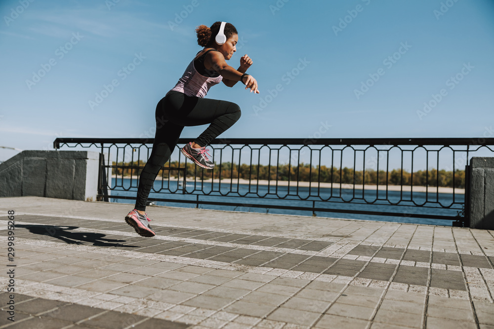 Afro American young woman jumping on the street Afro American young woman jumping on the street