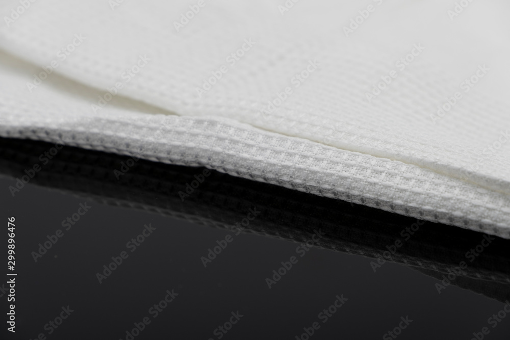 Macro shot texture of folded white towel kitchen fabric isolated on black background Macro shot texture of folded white towel kitchen fabric isolated on black background