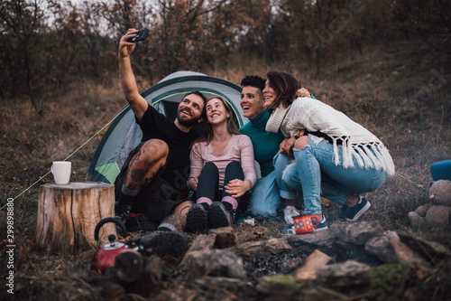 Young friends laughing, taking selfie,hanging out at campsite © skunevski