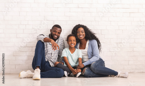 Happy Black Family With Little Daughter Sitting On Floor Together