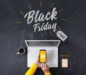 Black friday advertisement on blackboard. Woman shopping with smart phone app.
