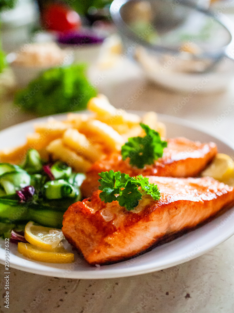 Fried salmon, French fries and vegetables