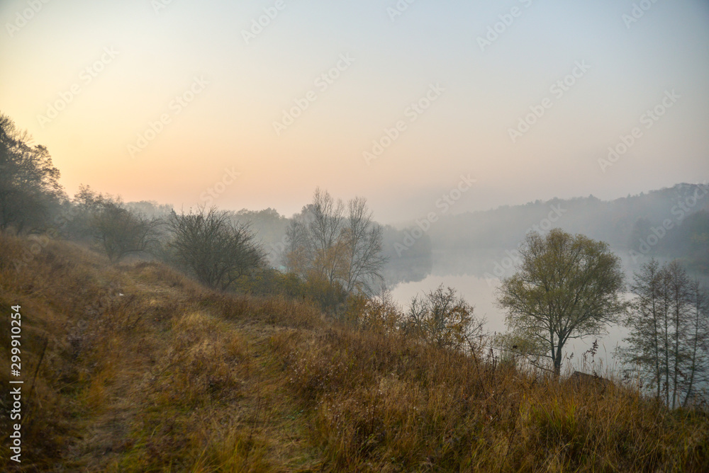 Morning in autumn forest with lake