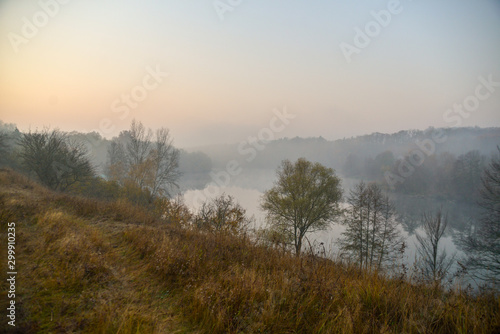Morning in autumn forest with lake