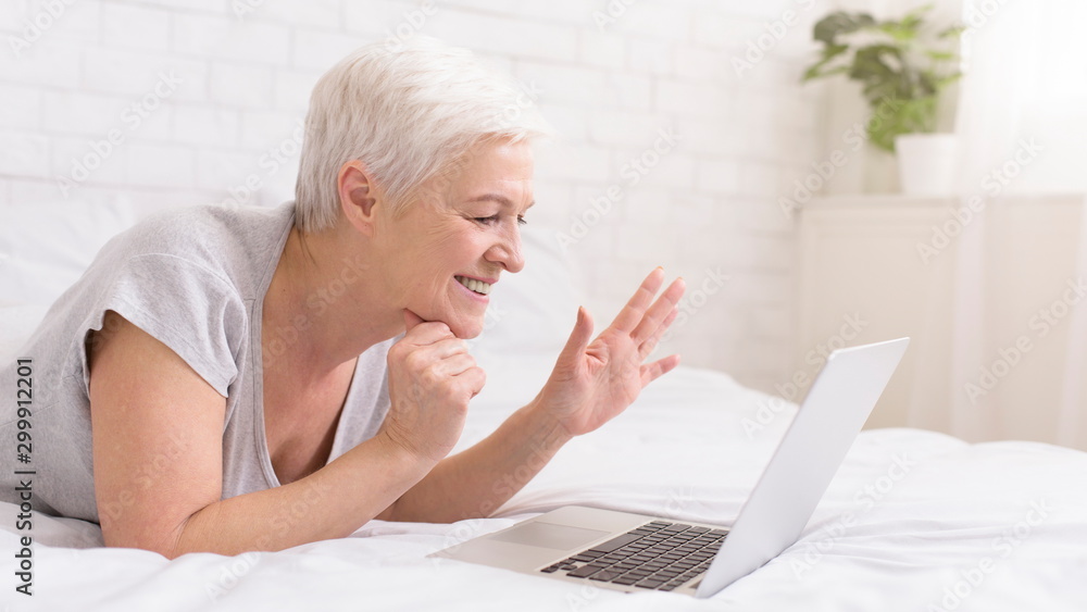 Cheerful grandmother talking with relatives via digital tablet online Cheerful grandmother talking with relatives via digital tablet online