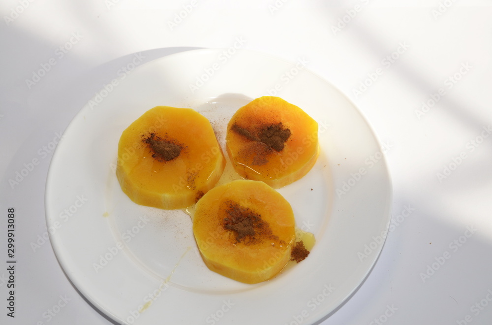 Vegetarian Diet Food. On a white plate are slices of baked pumpkin with honey and cinnamon.