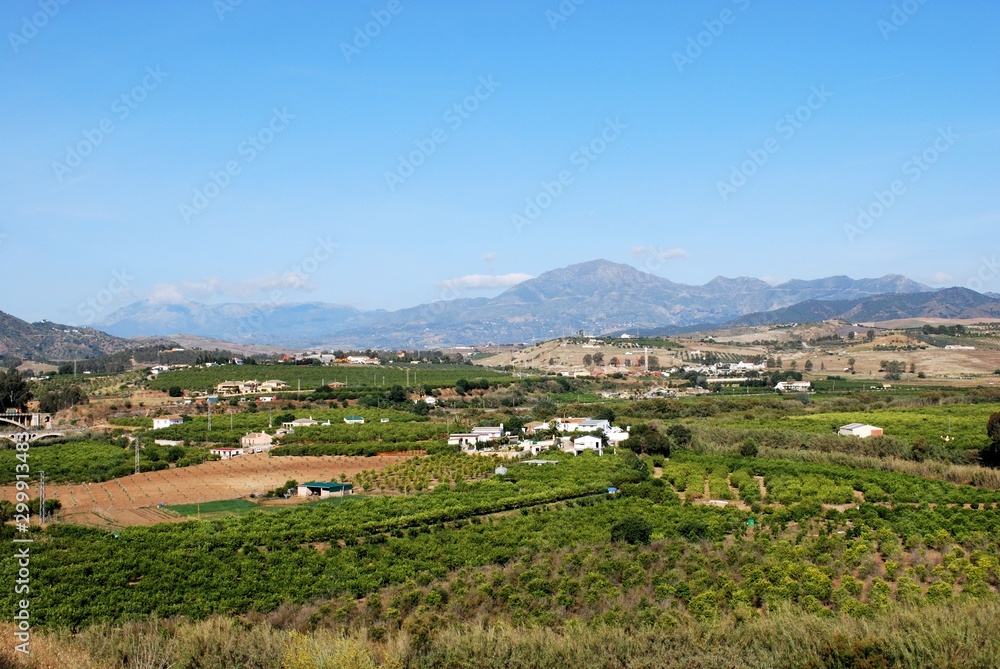 Farmland and houses in the valley with views towards the mountains near Alora, Spain.