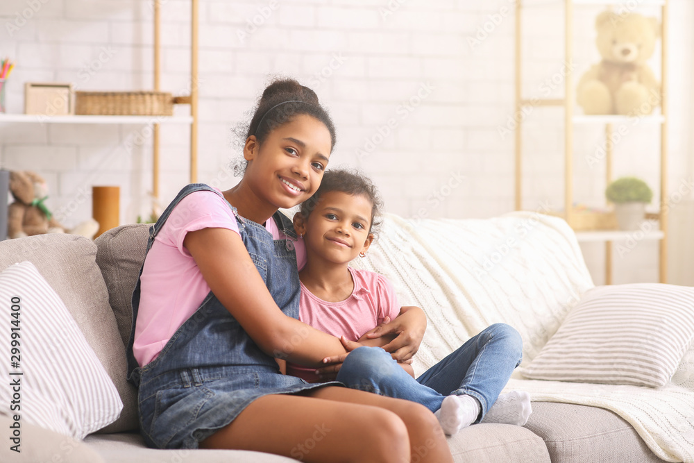 Cheerful african american sisters hugging at home Cheerful african american sisters hugging at home