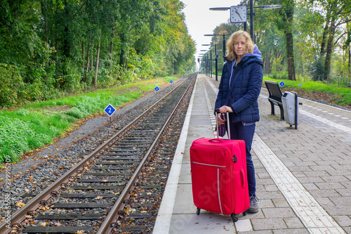 Foto Dutch woman with suitcase stands on train station