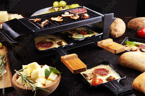 Canvas Print Delicious traditional Swiss melted raclette cheese on diced boiled or baked potato
