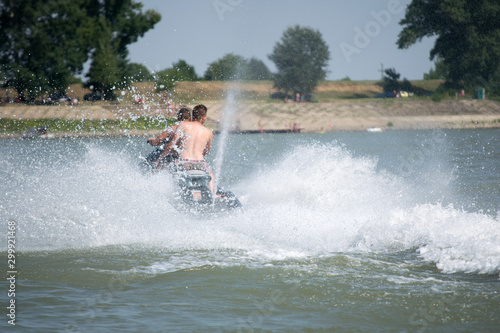 teenagers driving a jet ski on the river