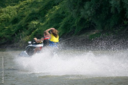 teenagers driving a jet ski on the river