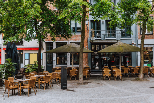 Old street with tables of cafe in historic city center of Antwerpen (Antwerp), Belgium. Cozy cityscape of Antwerp. Architecture and landmark of Antwerpen photo