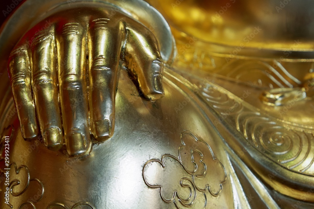 Golden hand of buddha statue on knee, Holy object in  Chinese temple in Thailand.