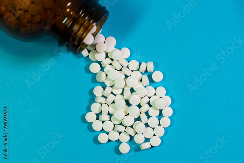 pills and bottle on blue background