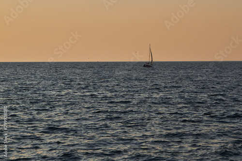 Sailing boat with a beautiful sunset at the sea © piratepike