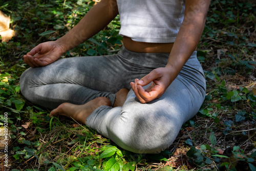young woman doing the lotus pose in the forest photo