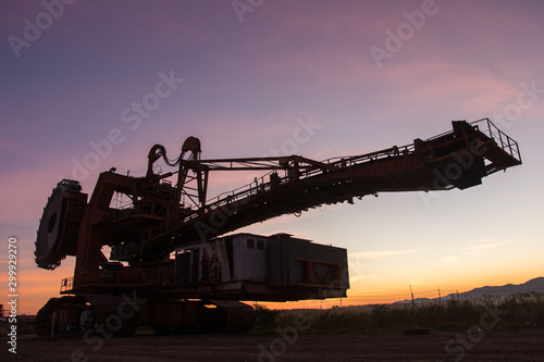 silhouette of coal mining machine on mine at sunrise with beautiful skies