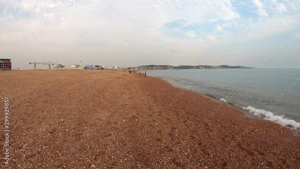 Golden Pebble beach with dark brown sand on overcast day, Jinshitan, China, static Golden Pebble beach with dark brown sand on overcast day, Jinshitan, China, static