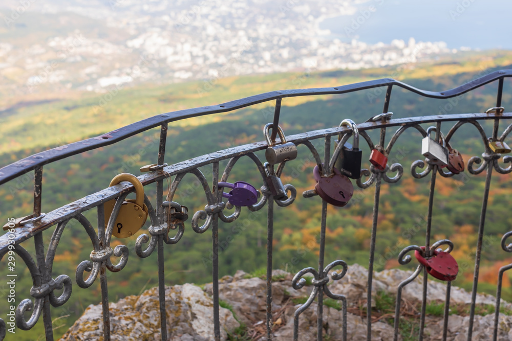 Love padlocks on iron fence. Different love locks on railing. Viewpoint Silver Arbor on road from Yalta to Ai-Petri Love padlocks on iron fence. Different love locks on railing. Viewpoint Silver Arbor on road from Yalta to Ai-Petri