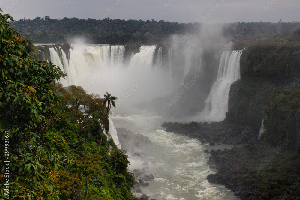 The main attraction of Brazil and Argentina is the famous Iguazu Falls among the lush green jungle. Huge streams of water fall to the ground. UNESCO World Heritage. Picture from paradise.