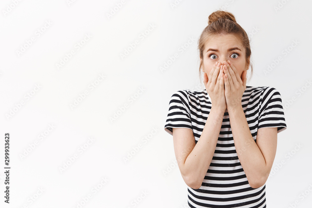 Shocked concerned young caucasian woman with messy bun, gasping holding breath stunned, cover mouth with hands and stare camera scared for you, frightened caused accident, white background Shocked concerned young caucasian woman with messy bun, gasping holding breath stunned, cover mouth with hands and stare camera scared for you, frightened caused accident, white background