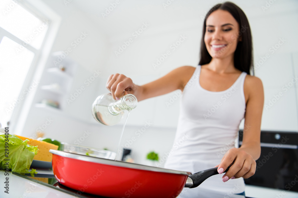 Low angle photo of positive cheerful brown hair girl want cook delicious tasty dish prepare frying pan pouring oil have rest relax free time in house white kitchen indoors Low angle photo of positive cheerful brown hair girl want cook delicious tasty dish prepare frying pan pouring oil have rest relax free time in house white kitchen indoors