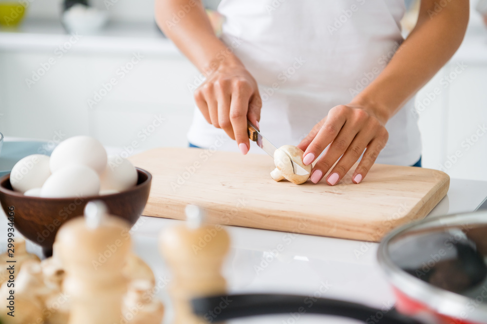 Cropped close up photo of stylish woman gourmet veggie cut mushroom on chopping board prepare fest have bowl with fresh eggs in house white kitchen
