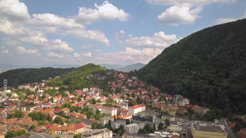 Aerial view of Brasov city, medieval town situated in Transylvania, Romania. Old architecture surrounded with big Carpathian mountains covered with dense green forest. Aerial view of Brasov city, medieval town situated in Transylvania, Romania. Old architecture surrounded with big Carpathian mountains covered with dense green forest.