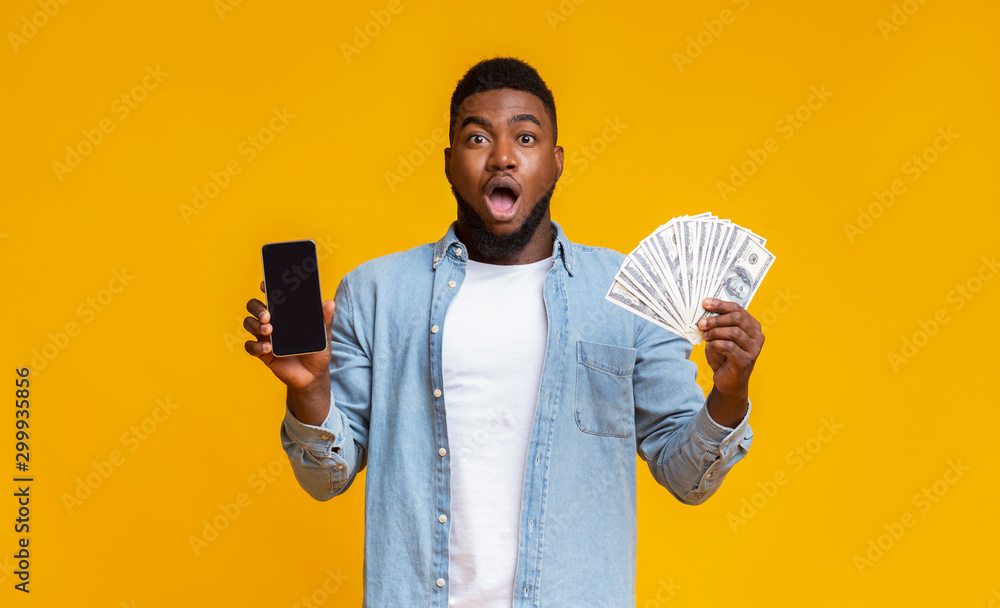 Afro guy holding cellphone with black screen and dollar cash Afro guy holding cellphone with black screen and dollar cash