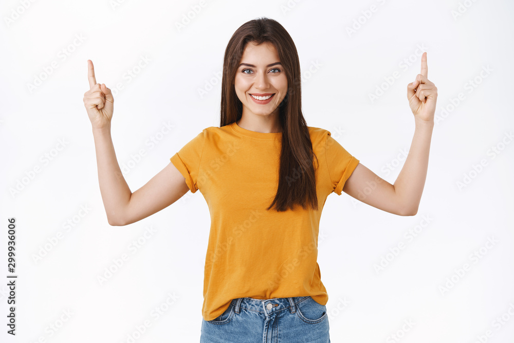 Cheerful, attractive woman in yellow t-shirt smiling and friendly showing interesting promo event, pointing raised fingers up, grinning, give advice what page visit, recommend participate event Cheerful, attractive woman in yellow t-shirt smiling and friendly showing interesting promo event, pointing raised fingers up, grinning, give advice what page visit, recommend participate event