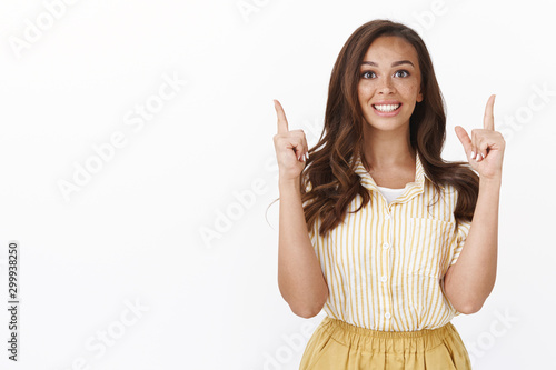 Valokuva Optimistic, energized gorgeous young caucasian woman pointing up and smiling too