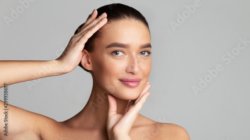 Fotografie Beautiful woman touching face and looking at camera