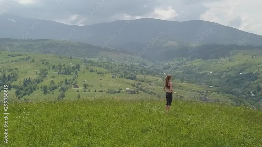 Young woman enjoying mountain view on a summer day. Relax and meditation in nature environment. Young woman enjoying mountain view on a summer day. Relax and meditation in nature environment.