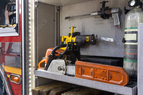 Fire truck compartment with chainsaw and other tools.