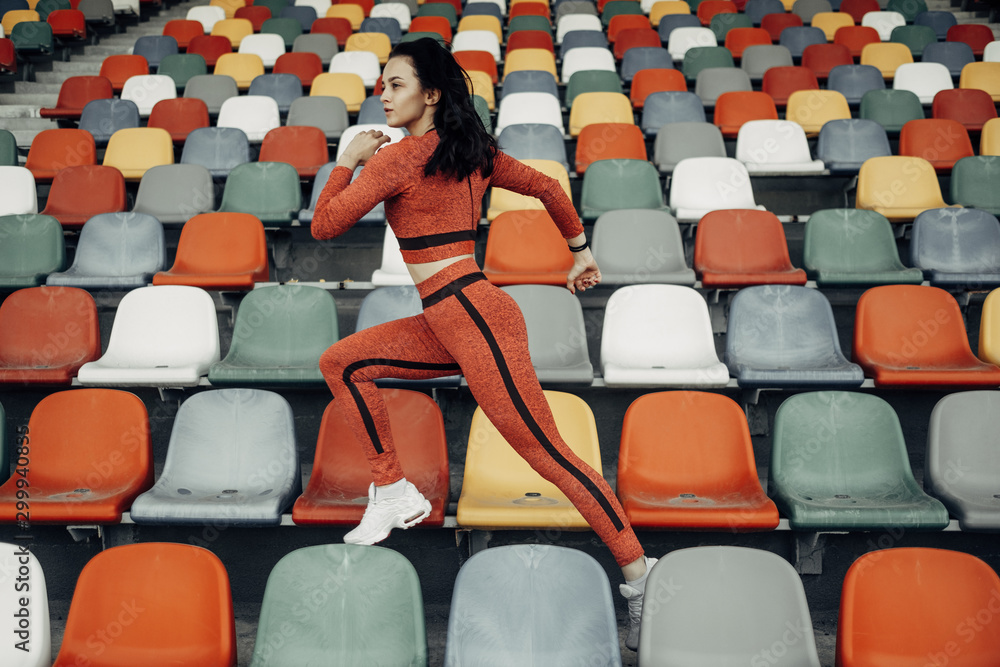 Naklejka premium Portrait of One Sports Fitness Girl Dressed Fashion Sportswear Outfit Doing Jogging and Run at the City Stadium, Healthy Lifestyle Concept