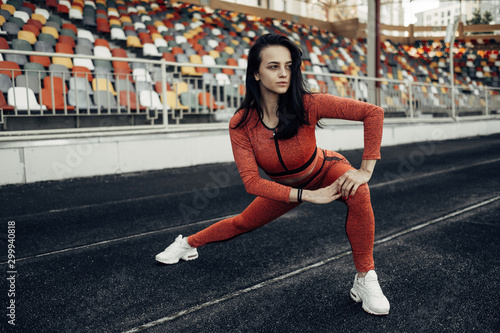Portrait of One Sports Fitness Girl Dressed Fashion Sportswear Outfit Doing Stretches Exercise and Training at the City Stadium, Healthy Lifestyle Concept