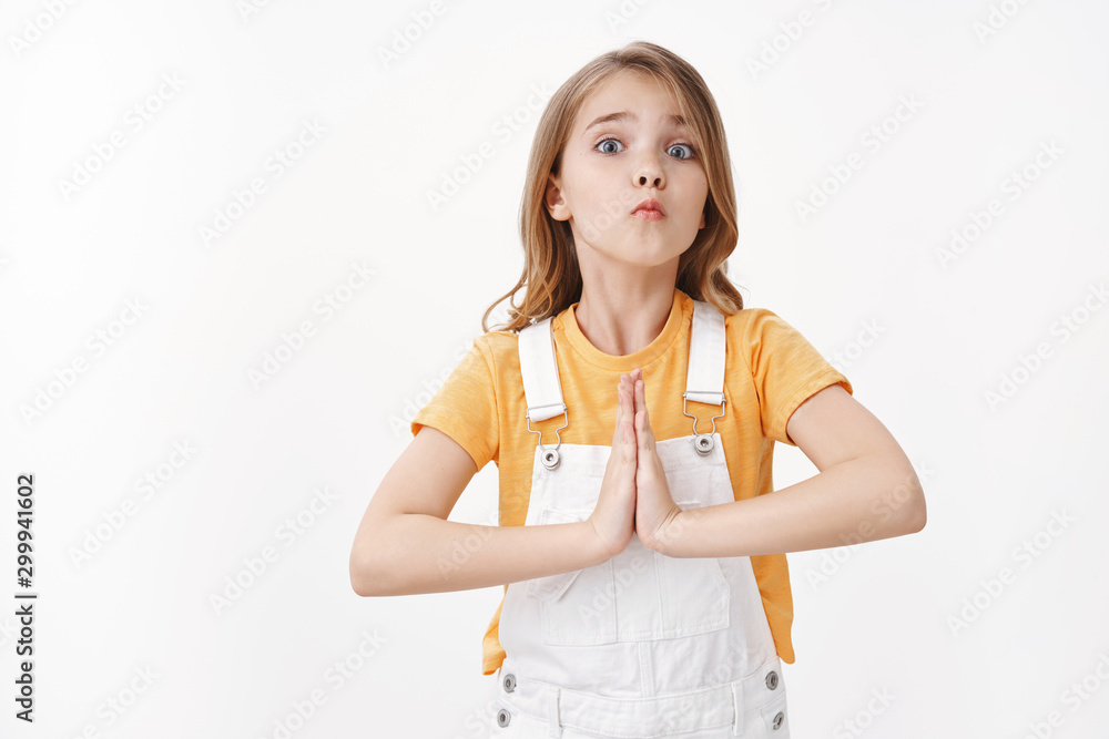 Silly pretty little girl, child begging buy new toy, hold hands pray, supplicating, pouting lips with tender cute gaze, acting lovely and childish, promise do homework after favor, white background Silly pretty little girl, child begging buy new toy, hold hands pray, supplicating, pouting lips with tender cute gaze, acting lovely and childish, promise do homework after favor, white background