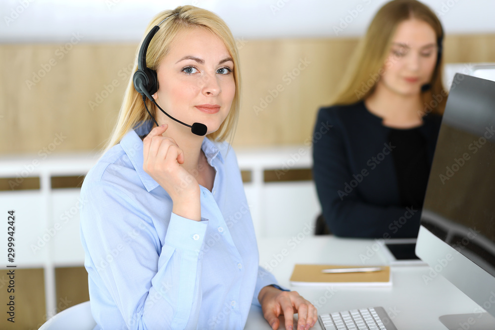 Call center. Blonde business woman sitting in headset at customer service office. Concept of telesales business or home office occupation Call center. Blonde business woman sitting in headset at customer service office. Concept of telesales business or home office occupation