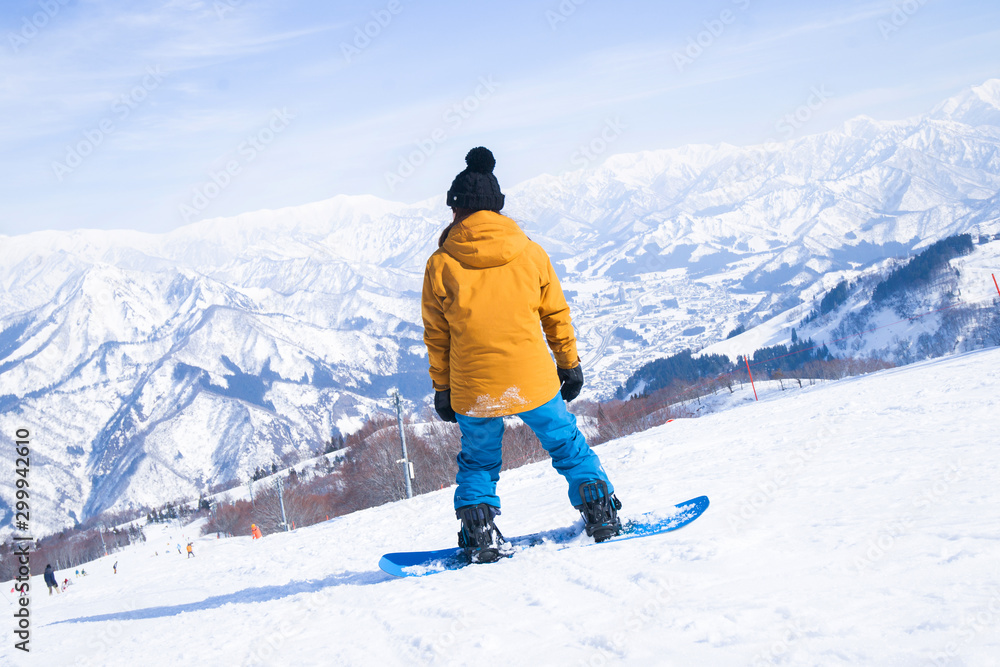Skier skiing downhill during sunny day in high mountains, Yuzawa Niigata Japan. Skier skiing downhill during sunny day in high mountains, Yuzawa Niigata Japan.