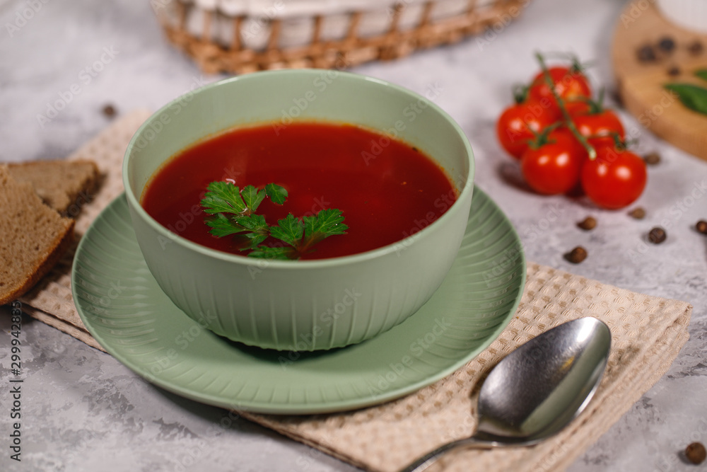 Beetroot soup with parsley in a plate, closeup. Tasty and hearty dinner. Borsch with vegetables on a gray background. Beetroot soup with parsley in a plate, closeup. Tasty and hearty dinner. Borsch with vegetables on a gray background.