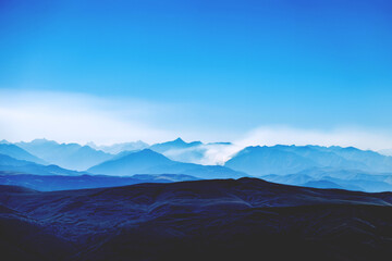 Acrylglasbilder Blau Caucasian ridge. Mountain blue landscape. Clouds over the valley  © Amina