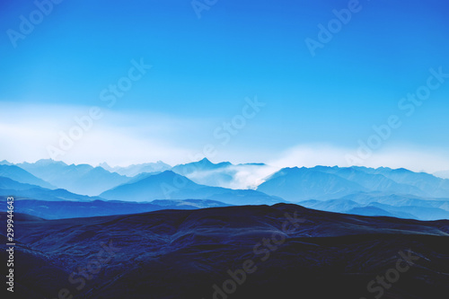 Caucasian ridge. Mountain blue landscape. Clouds over the valley