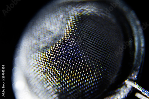 a tea strainer in close-up against black background