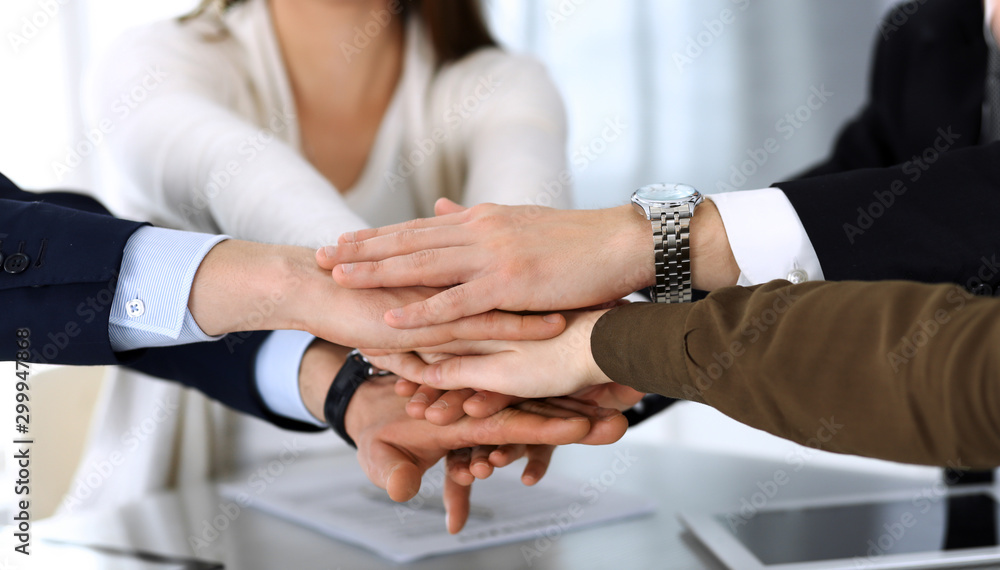 Obraz premium Business people group showing teamwork and joining hands or giving five after signing contract in modern office. Unknown businessman and woman with colleagues or lawyers making circle with their hands