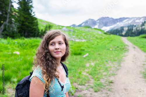 Albion Basin, Utah woman standing on summer dirt road meadows trail in 2019 in Wasatch mountains with rocky snowy Devil's Castle mountain
