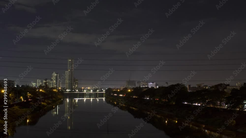 Stable timelapse viewing busy bridge and highway traffic road between the river at night Stable timelapse viewing busy bridge and highway traffic road between the river at night