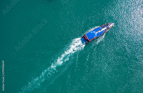 pleasure boat with tourists on Board floating in the sea, the trail with waves behind, top view from the drone